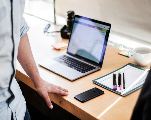 Person typing on a laptop computer in a Mexican home office setup