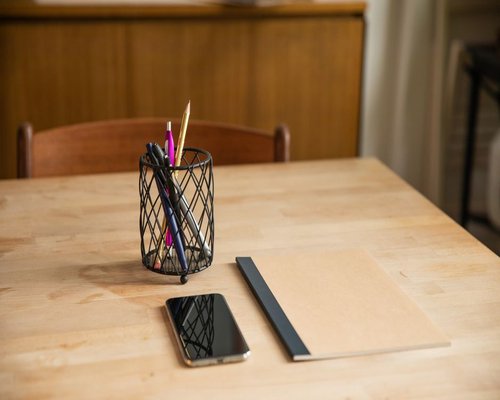 Smartphone and notebook on a tidy wooden table